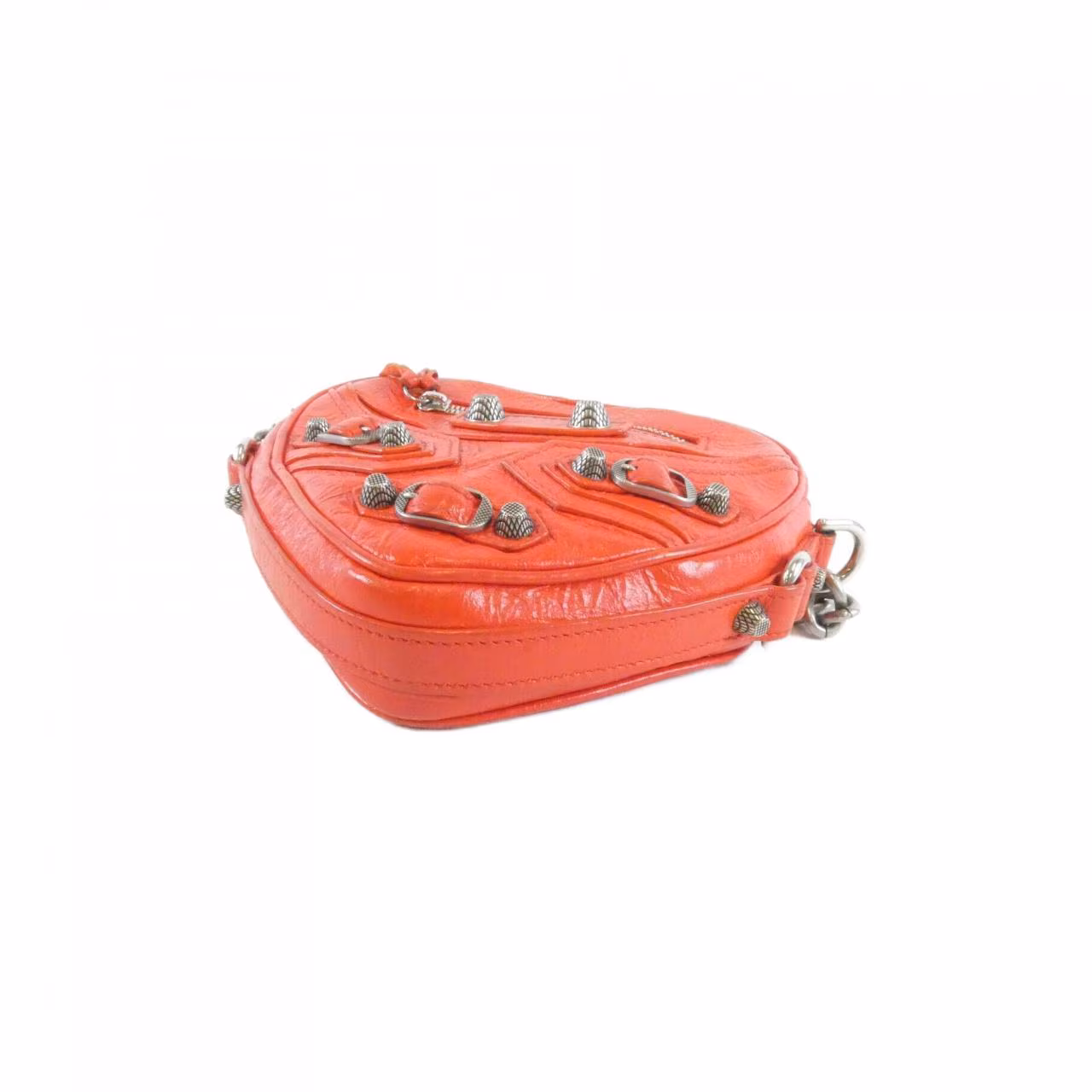 Small heart-shaped bag with studded hardware and a slim shoulder strap.