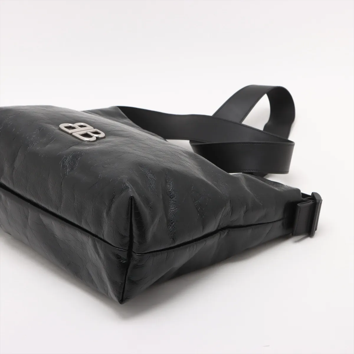 Black leather shoulder bag with chain strap and metal closure at the front flap.