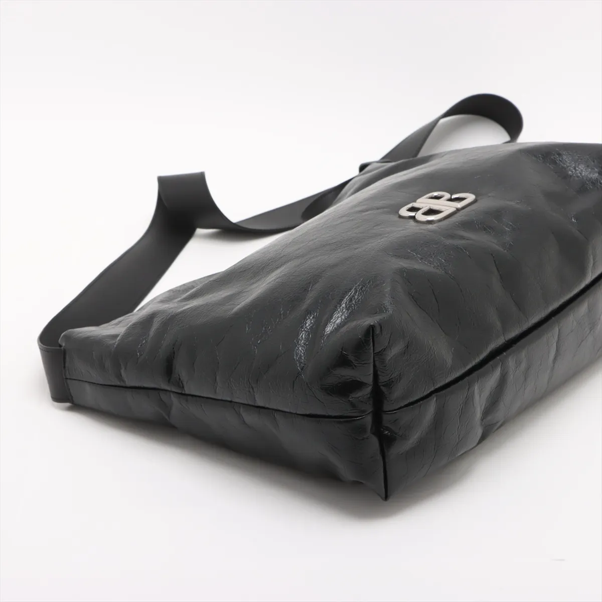 Black leather shoulder bag with chain strap and metal closure at the front flap.