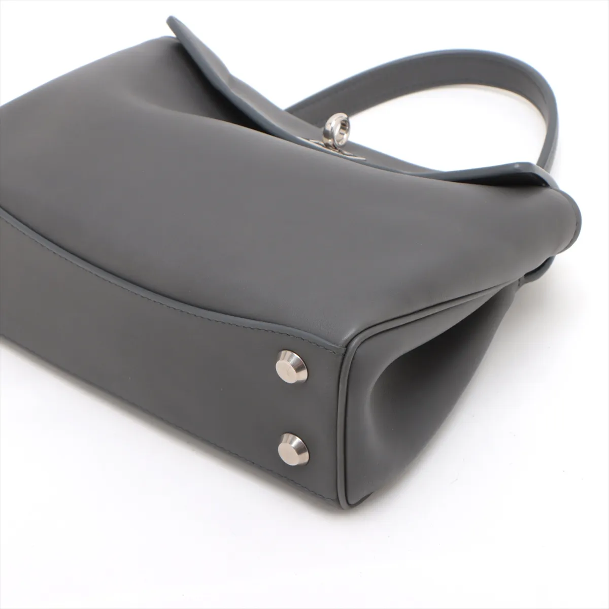 Grey leather handbag with top handle, hanging key holder and detachable shoulder strap.