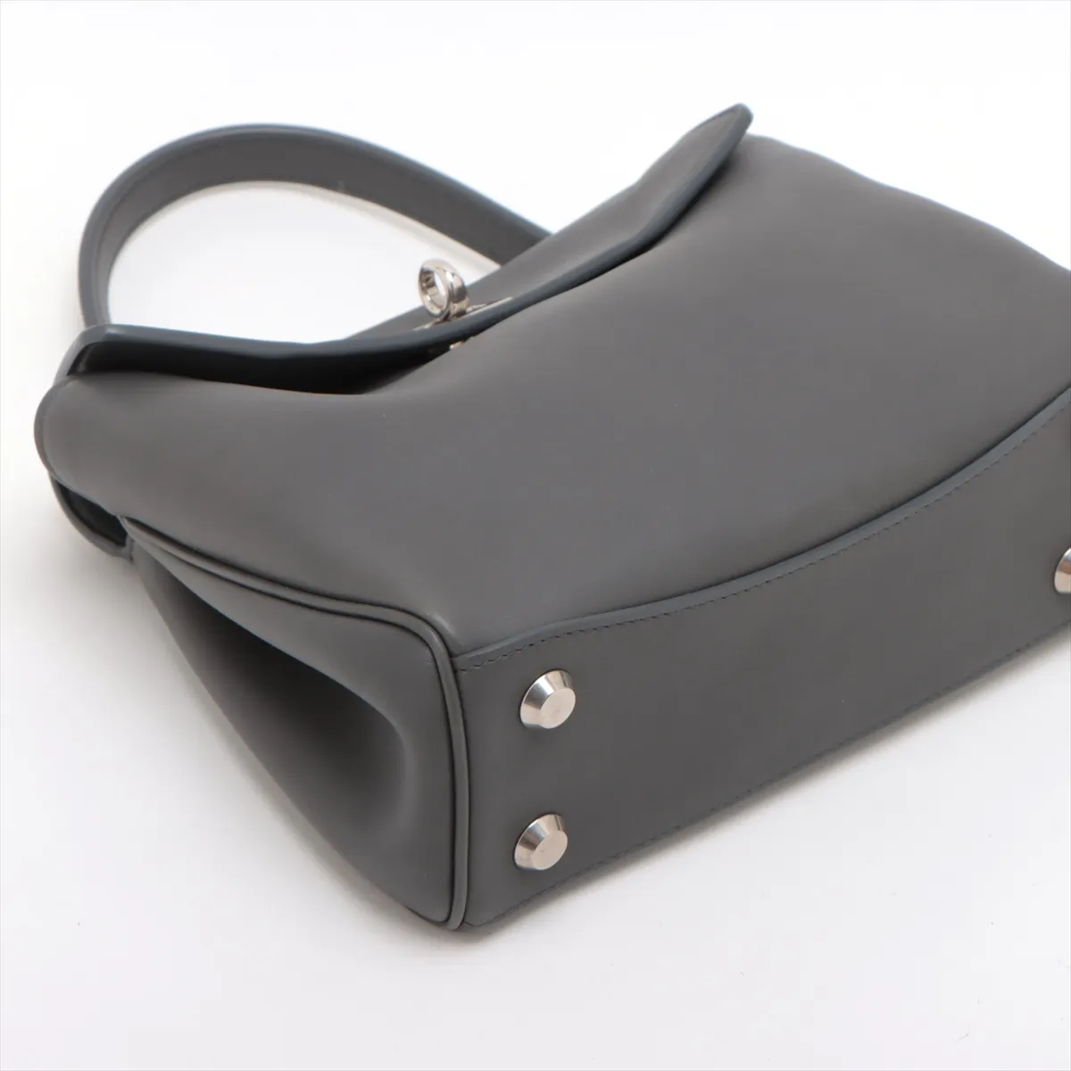 Grey leather handbag with top handle, hanging key holder and detachable shoulder strap.