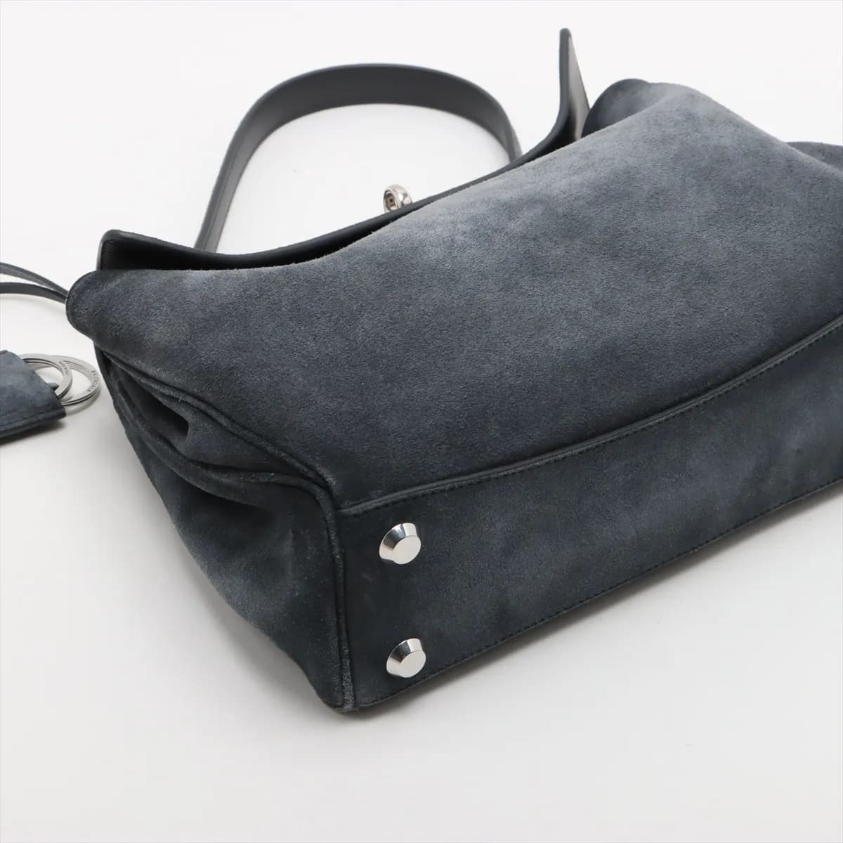 Slouchy grey suede handbag with a curved top handle, hanging key holder and detachable strap.