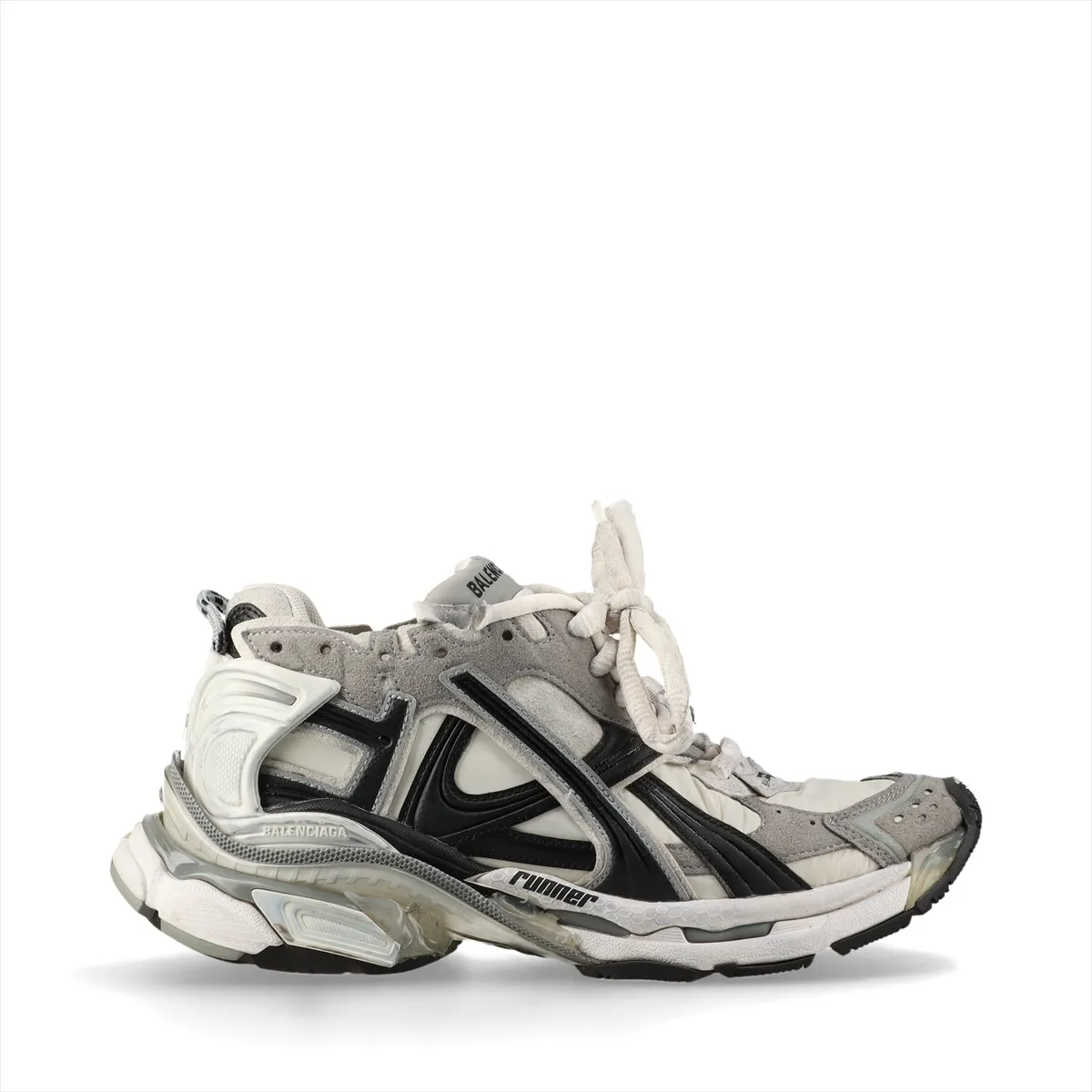 Grey low-top running-style sneakers with layered suede and fabric panels and an intentionally scuffed, aged finish.