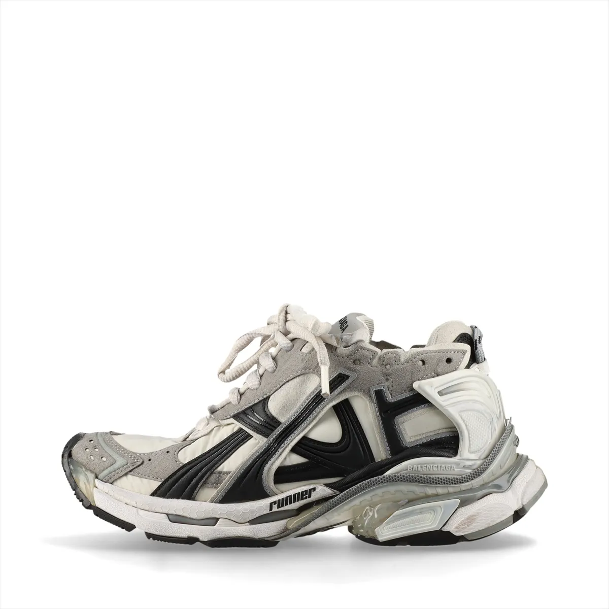 Grey low-top running-style sneakers with layered suede and fabric panels and an intentionally scuffed, aged finish.