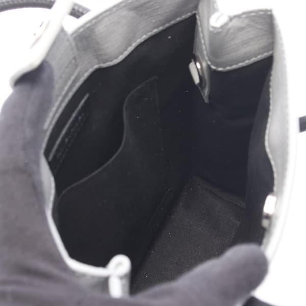 Small structured tote in grey and black leather with twin handles and a detachable strap.