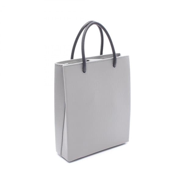 Small structured tote in grey and black leather with twin handles and a detachable strap.