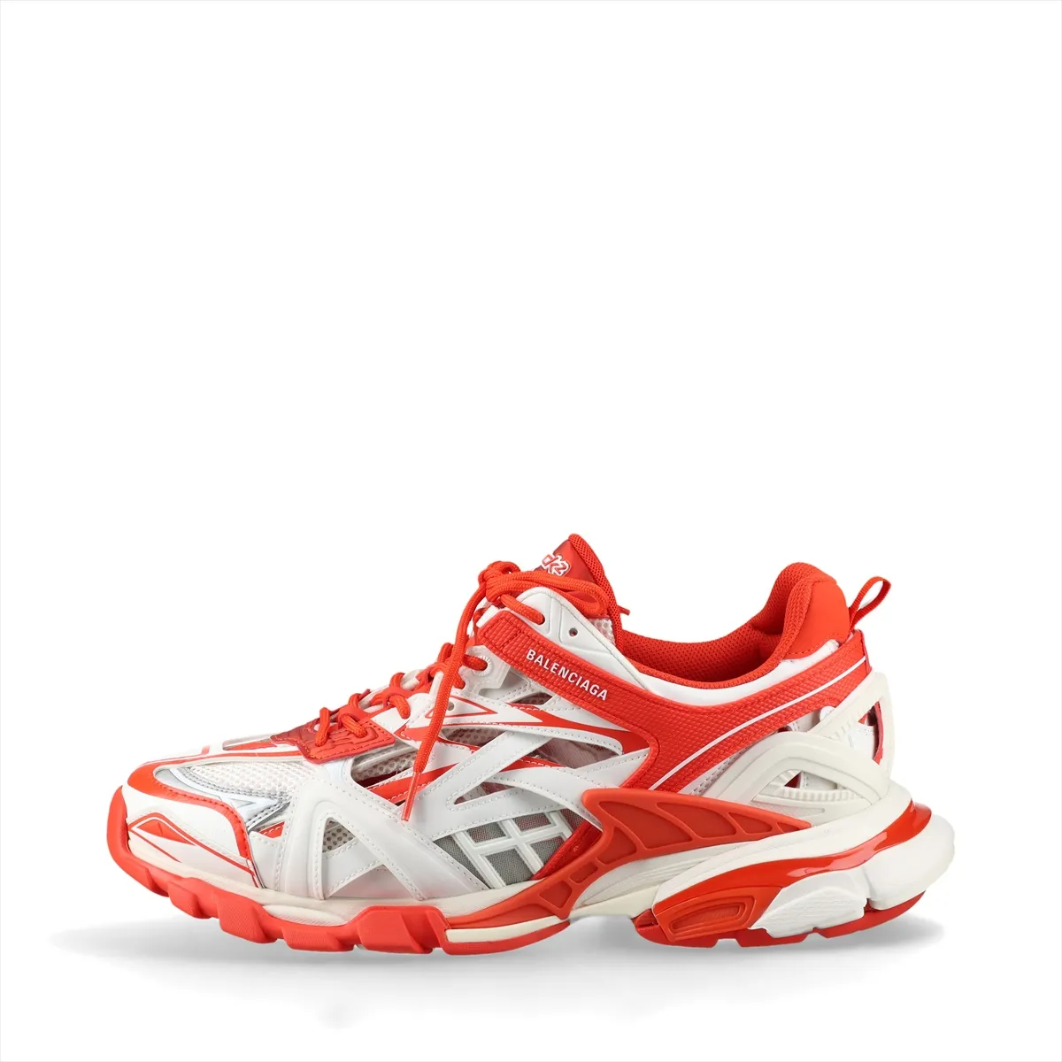 Chunky layered low-top sneakers in white with orange panels and mesh sections, shown in profile.