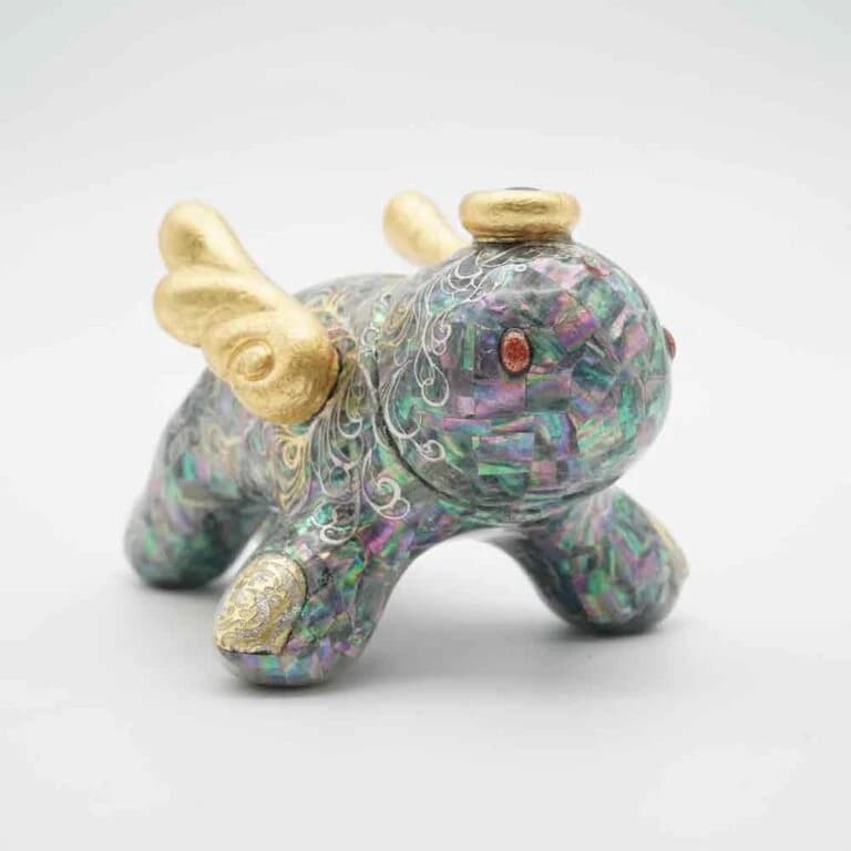 Small soft vinyl figure with iridescent shell inlay detailing across its surface.