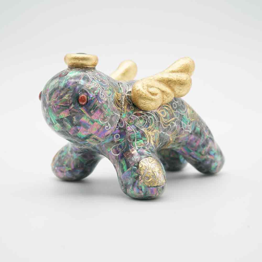 Small soft vinyl figure with iridescent shell inlay detailing across its surface.
