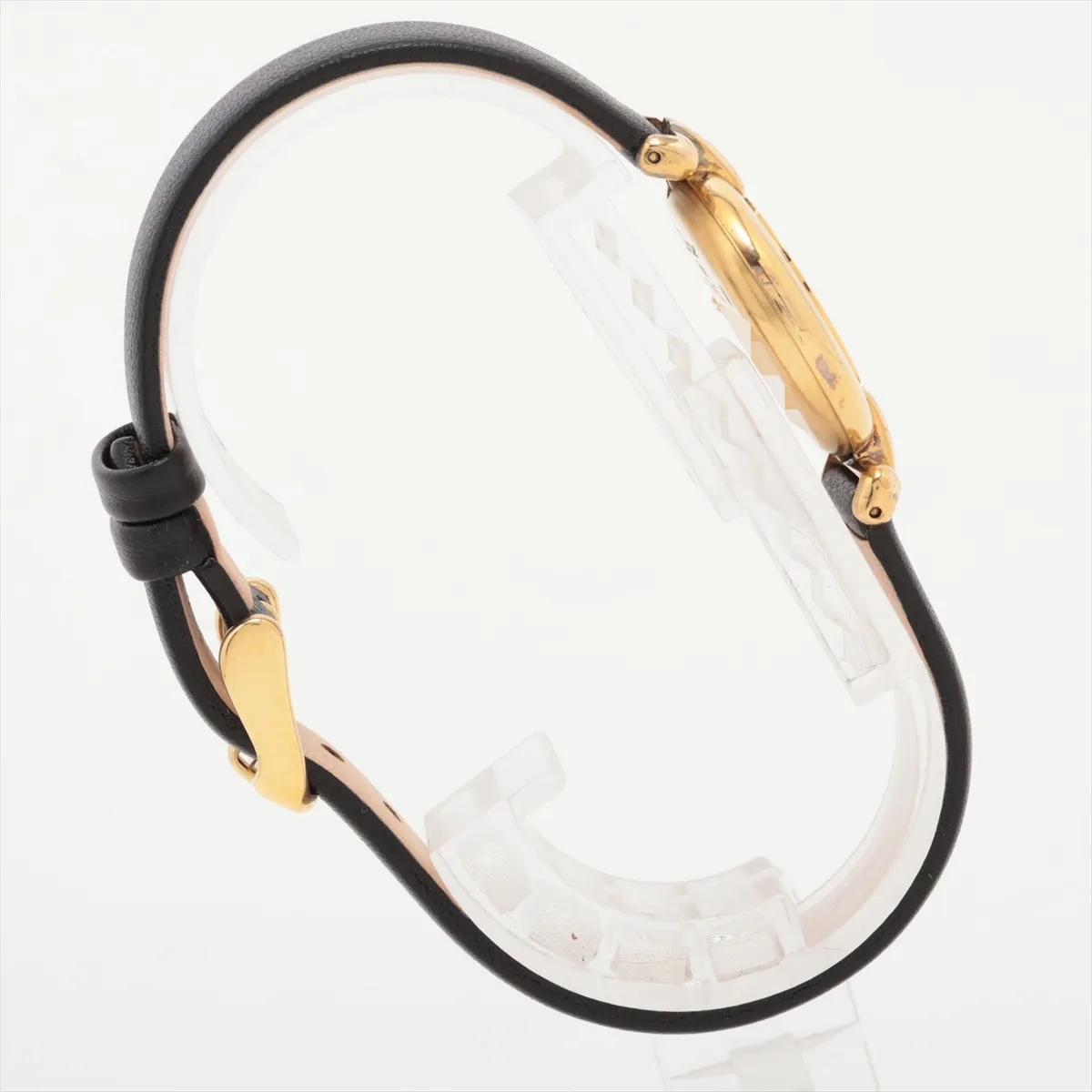 Small oval-cased wristwatch with champagne dial and dark leather strap.