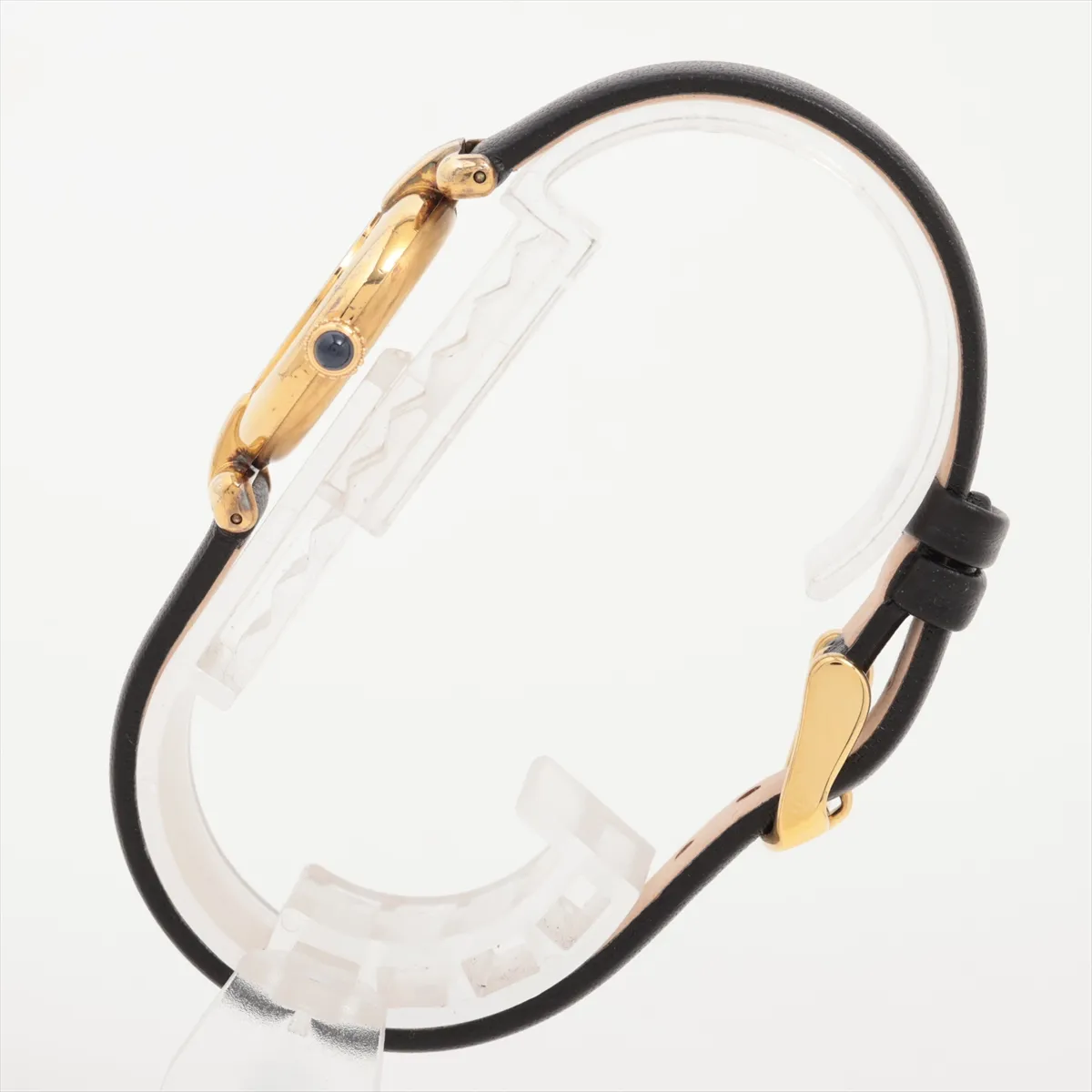 Small oval-cased wristwatch with champagne dial and dark leather strap.