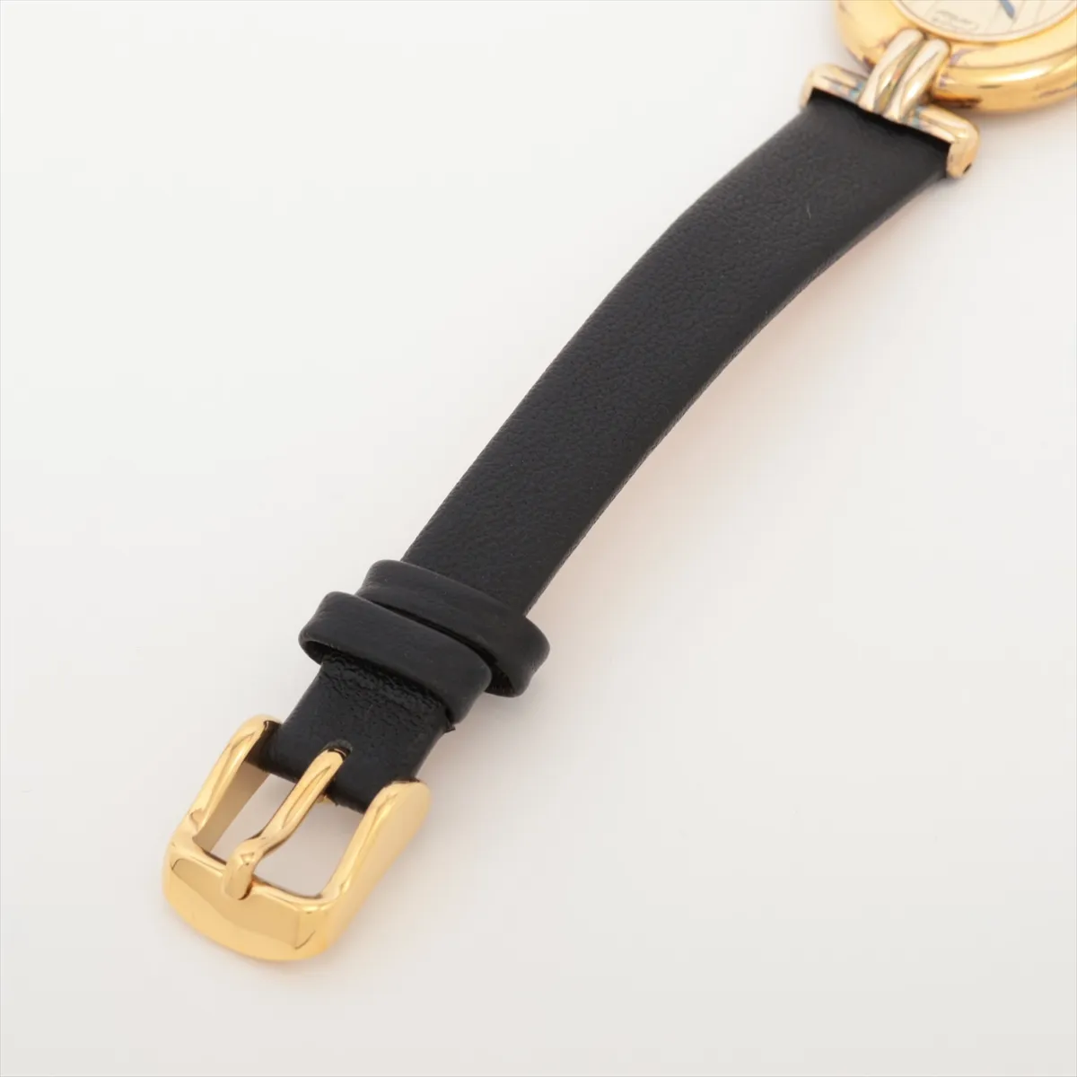 Small oval-cased wristwatch with champagne dial and dark leather strap.