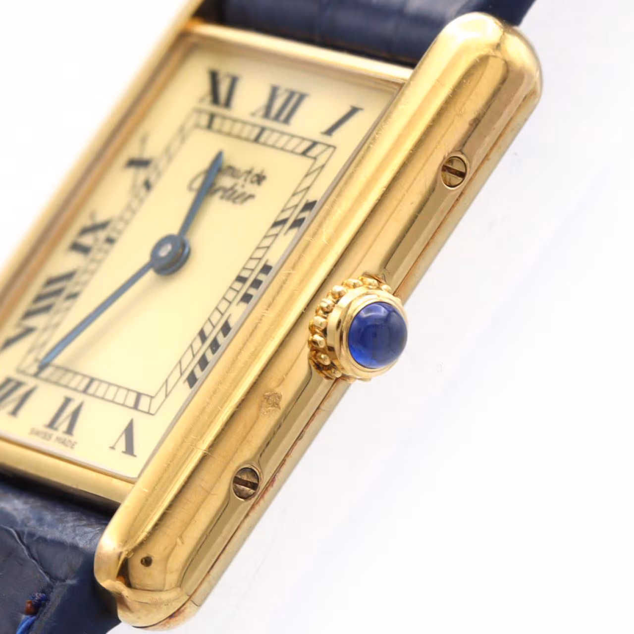 Rectangular gold-tone wristwatch with Roman numeral dial and a leather strap.