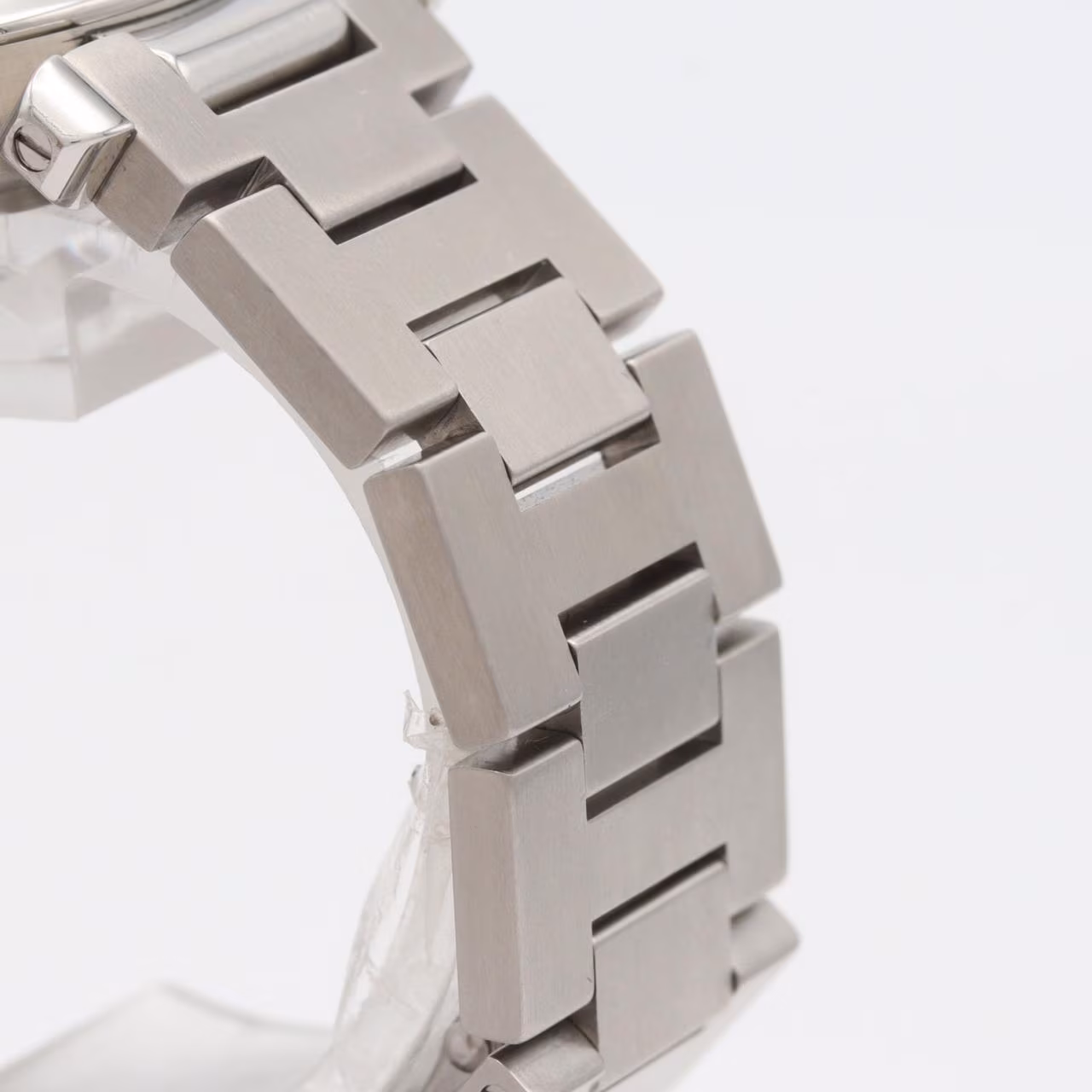 Round steel watch with large date aperture, chained crown cover and steel bracelet.