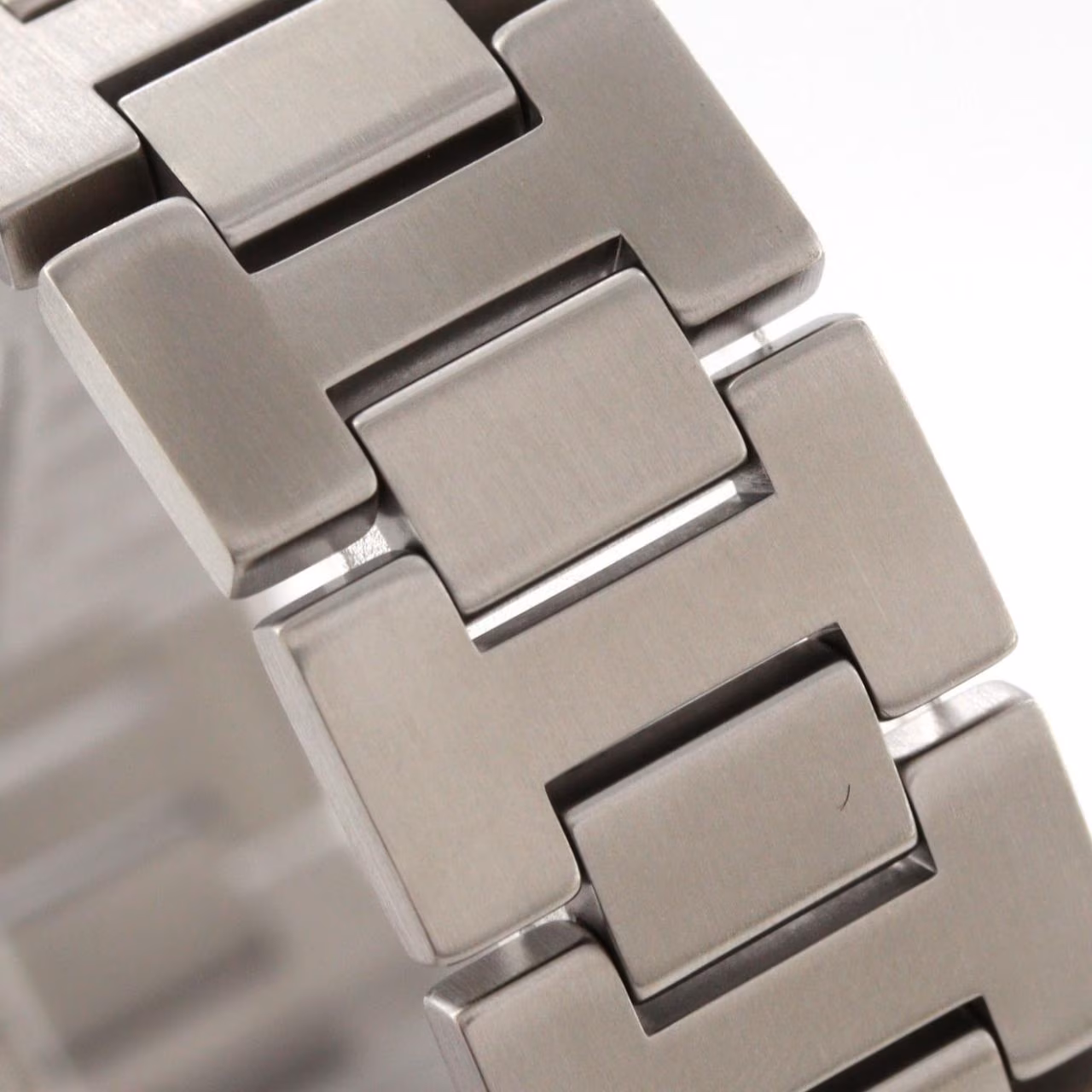 Round steel wristwatch with white dial, Arabic numerals and steel bracelet.