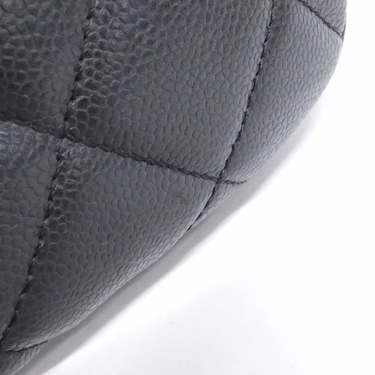 Black quilted leather bag with gold-tone chain handle and logo clasp.