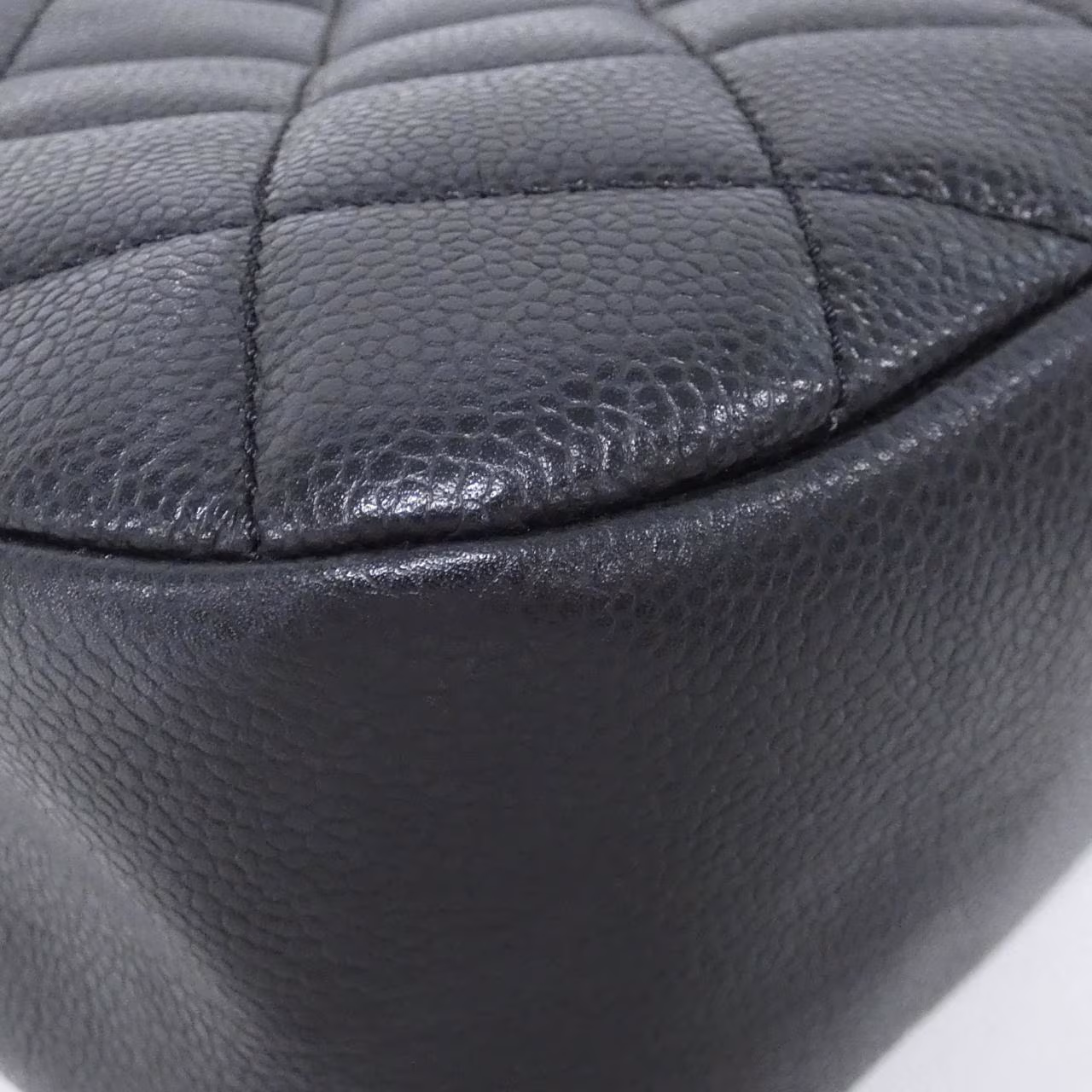 Black quilted leather bag with gold-tone chain handle and logo clasp.