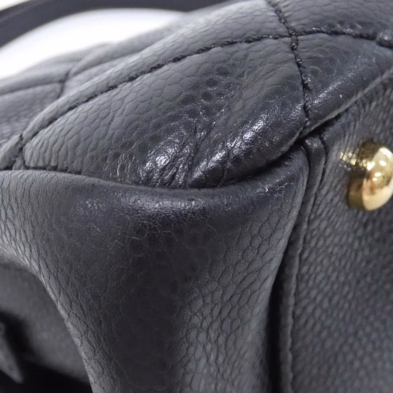 Black quilted shoulder bag with gold-tone chain strap and front flap closure.
