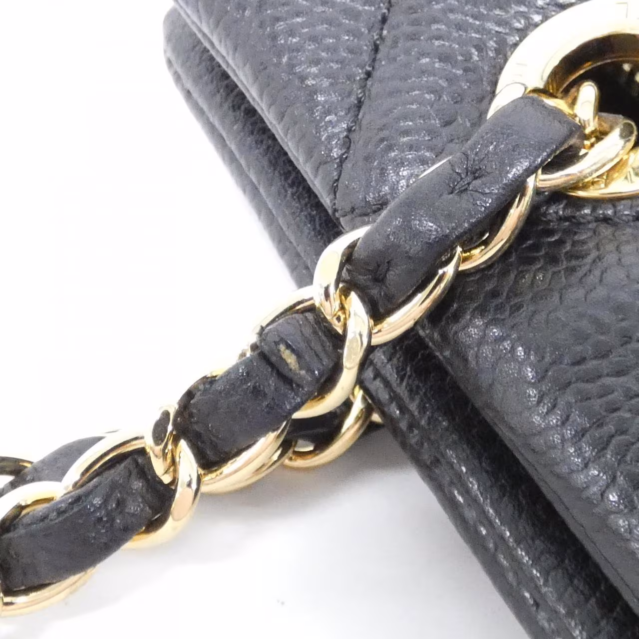 Black quilted shoulder bag with gold-tone chain strap and front flap closure.