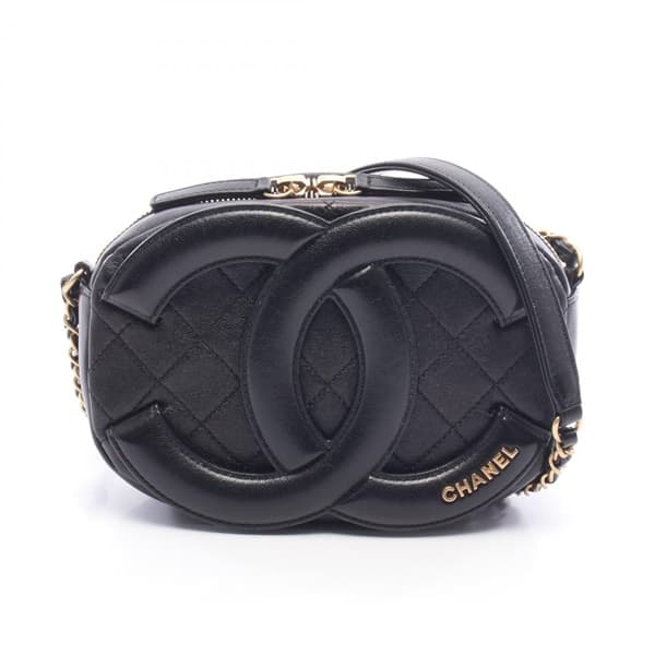 Black quilted leather camera bag with gold-tone logo clasp and a shoulder strap.