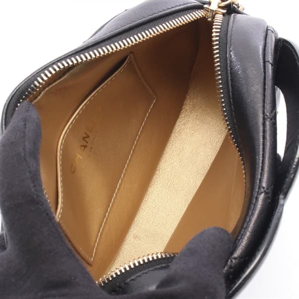 Black quilted leather camera bag with gold-tone logo clasp and a shoulder strap.