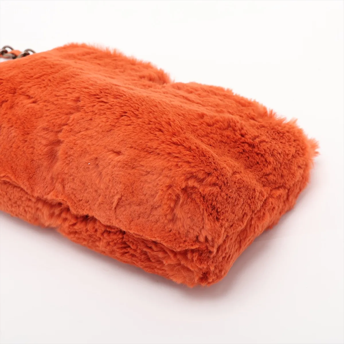 Small orange fur shoulder bag with a gold chain strap and interlocking logo clasp.