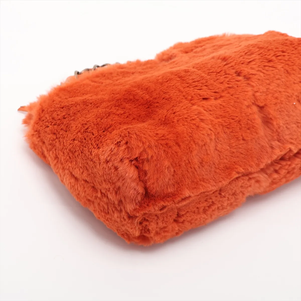 Small orange fur shoulder bag with a gold chain strap and interlocking logo clasp.