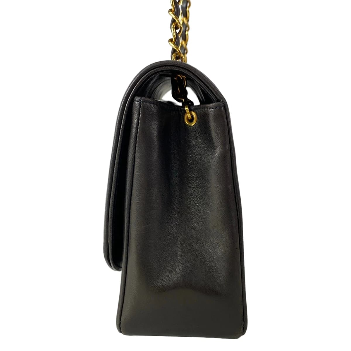 Quilted black flap bag with a turnlock closure and a thin chain-and-leather shoulder strap.