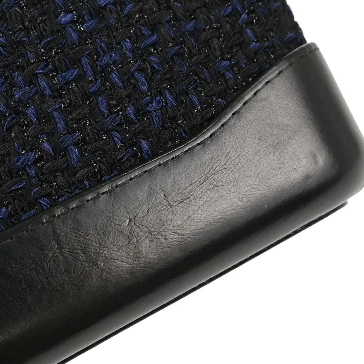 Small quilted navy tweed flap bag with a chain-and-leather shoulder strap.