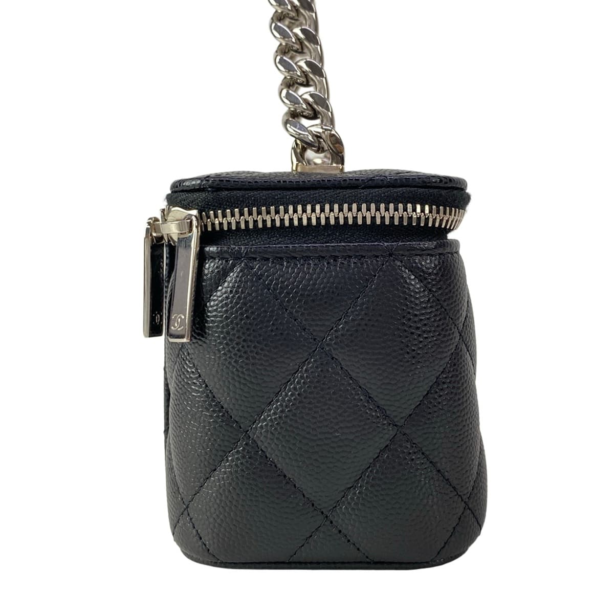 Small black quilted boxy bag with a top handle and chain strap.