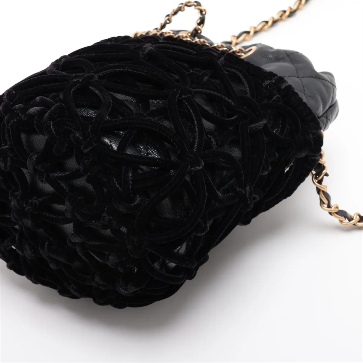 Black quilted drawstring bag with a gold chain strap and soft velour panels.