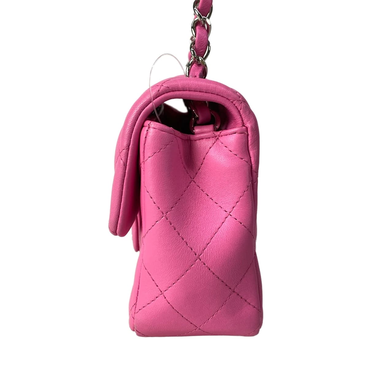 Small pink quilted bag with a chain shoulder strap.