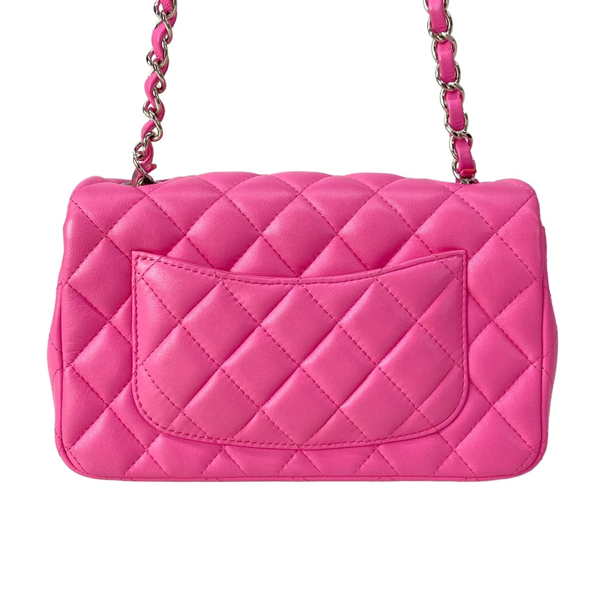 Small pink quilted bag with a chain shoulder strap.