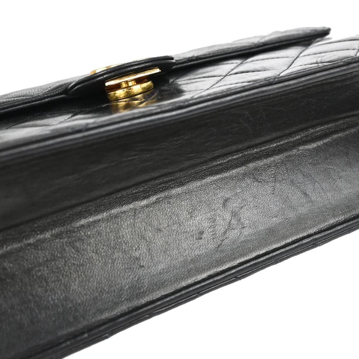 Black quilted leather flap bag with a chain and leather shoulder strap and a turnlock closure