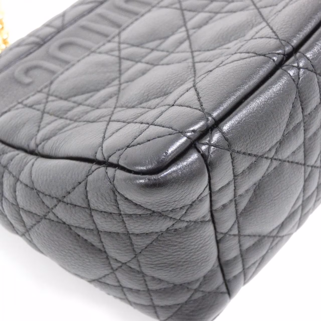 Quilted flap shoulder bag with a lettered clasp and a chain-and-leather strap.