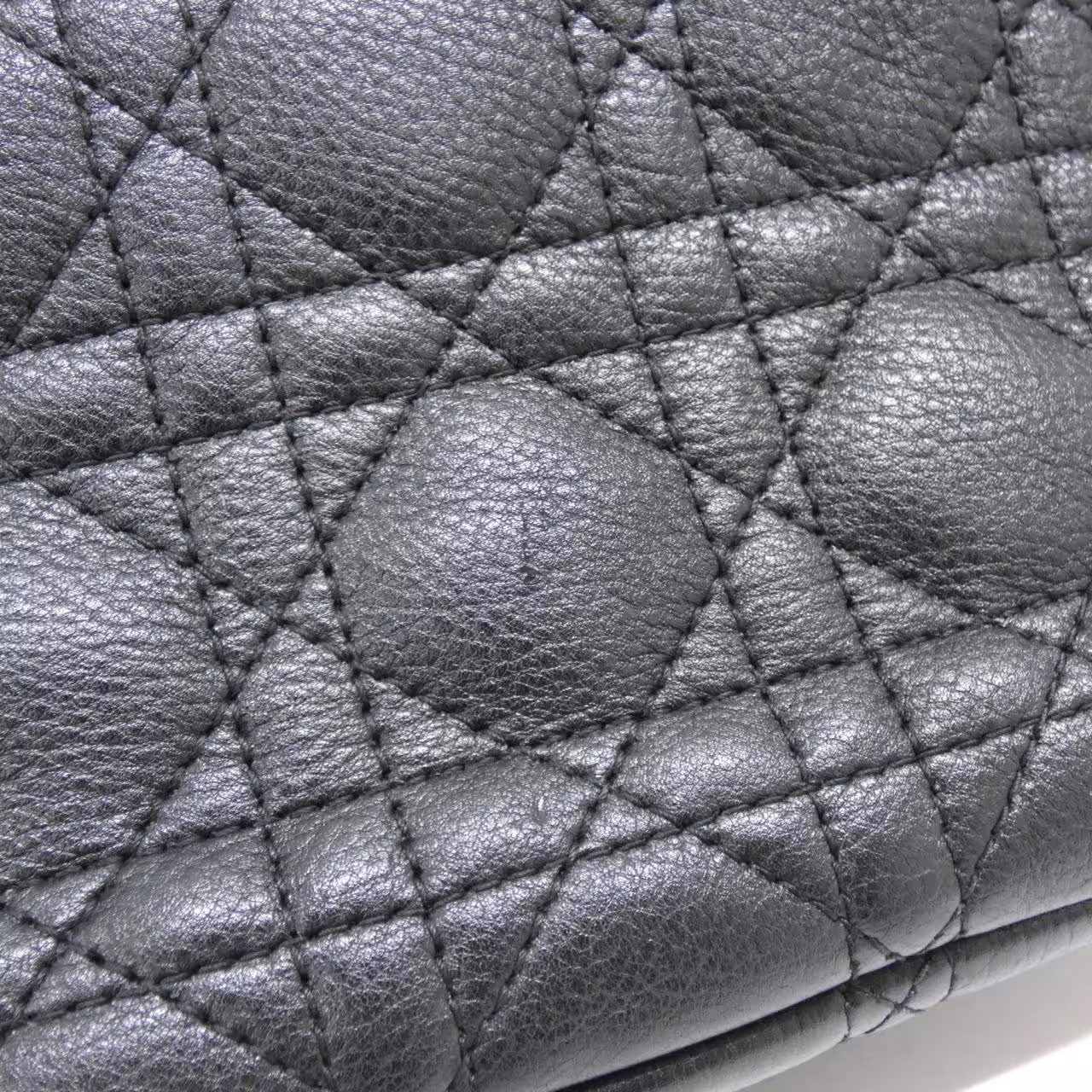 Quilted flap shoulder bag with a lettered clasp and a chain-and-leather strap.