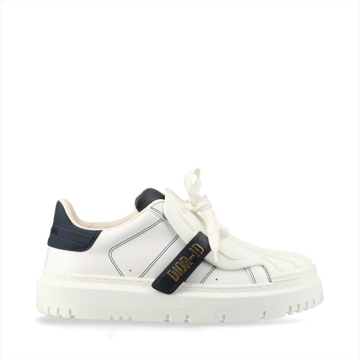 Pair of low-top sneakers in white with navy panels, chunky white sole, photographed on a plain background