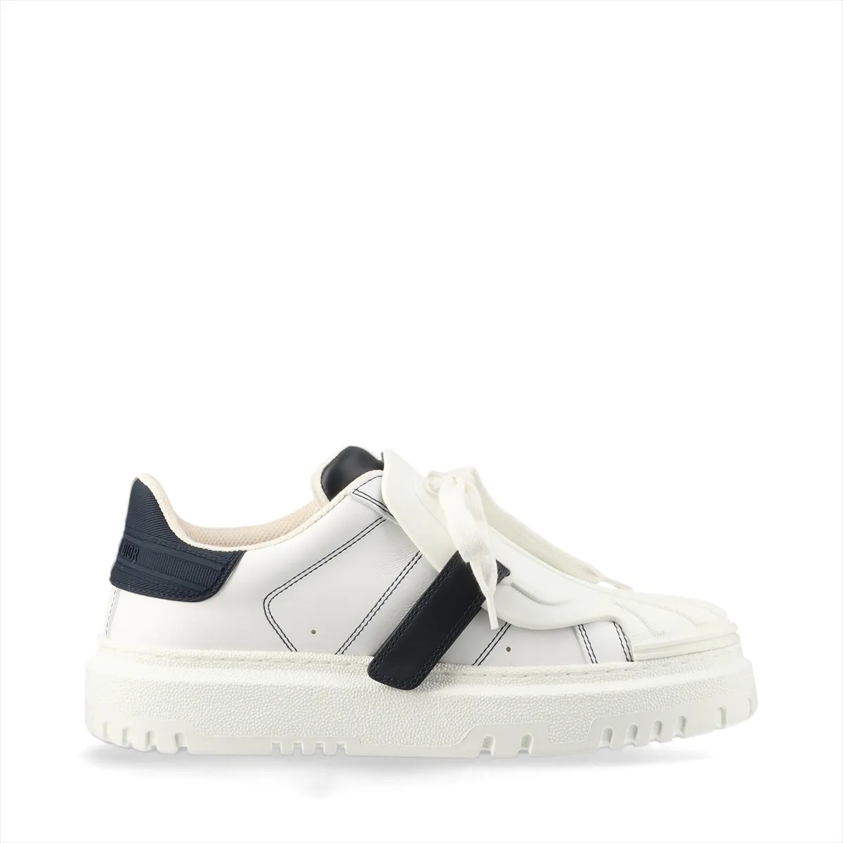 Pair of low-top sneakers in white with navy panels, chunky white sole, photographed on a plain background