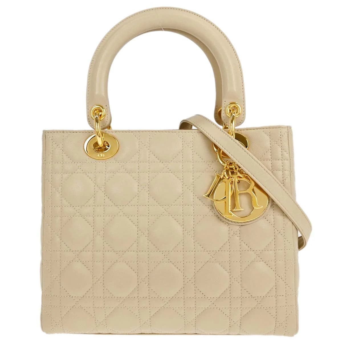 Beige quilted lambskin bag with top handles and hanging charms.