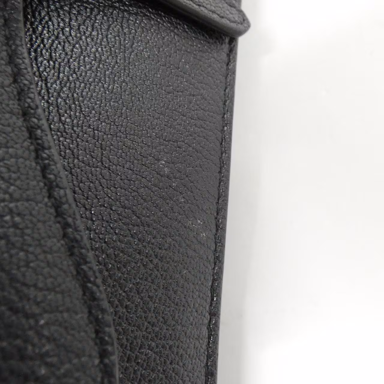 Saddle-shaped pouch with a curved flap and a belt loop at the back.