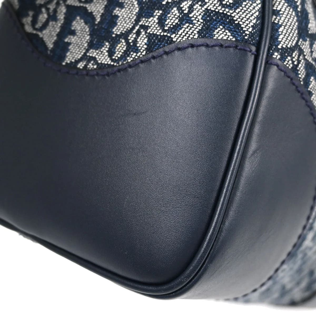 Navy monogram-patterned canvas handbag with leather trim and a small padlock.