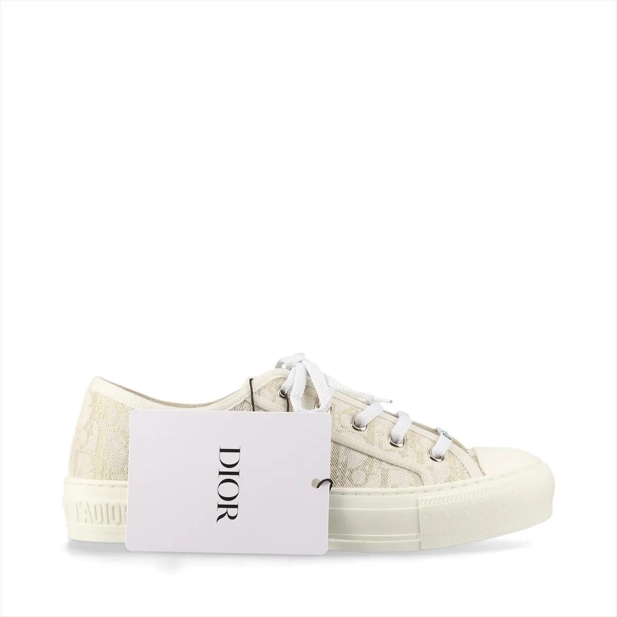 Low-top fabric sneakers with all-over monogram-style pattern in white and gold tones.