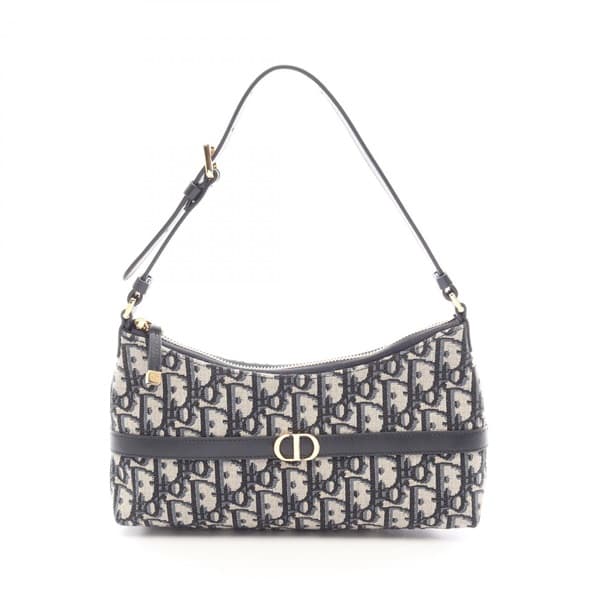 Beige and navy patterned canvas handbag with leather trim and a front flap closure.
