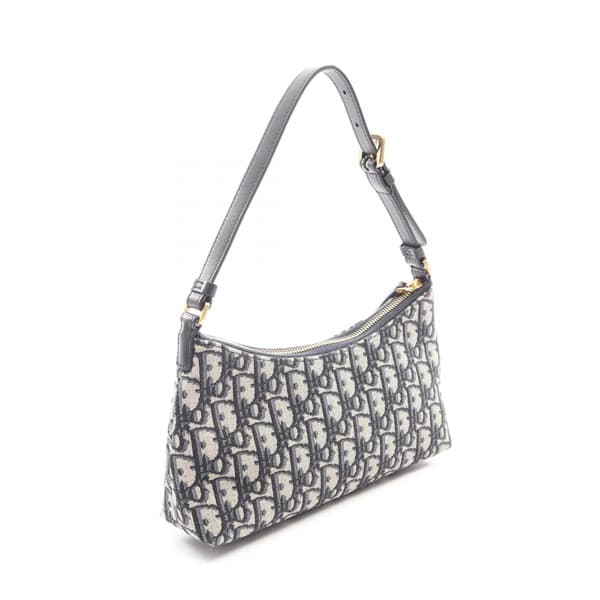 Beige and navy patterned canvas handbag with leather trim and a front flap closure.