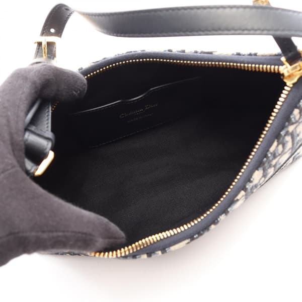 Beige and navy patterned canvas handbag with leather trim and a front flap closure.