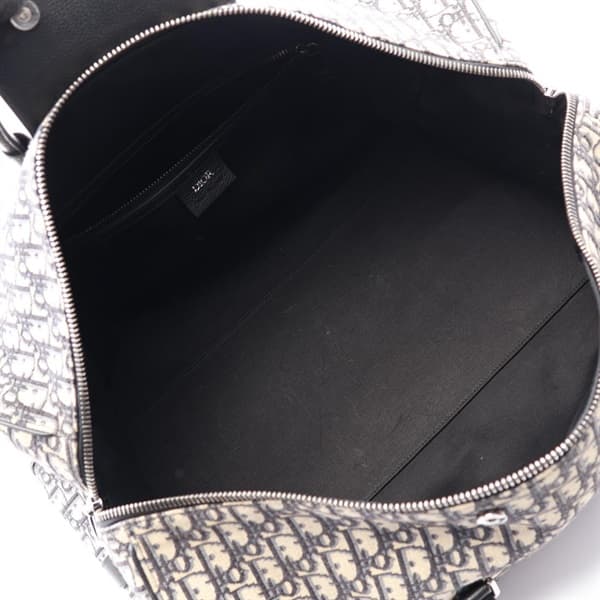 Navy and beige patterned canvas duffle bag with leather handles and trim.