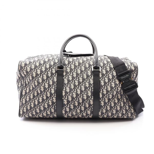 Navy and beige patterned canvas duffle bag with leather handles and trim.