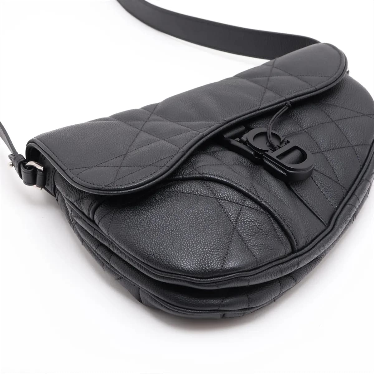 Black quilted leather saddle-shaped bag with star motif stitching and a wide shoulder strap