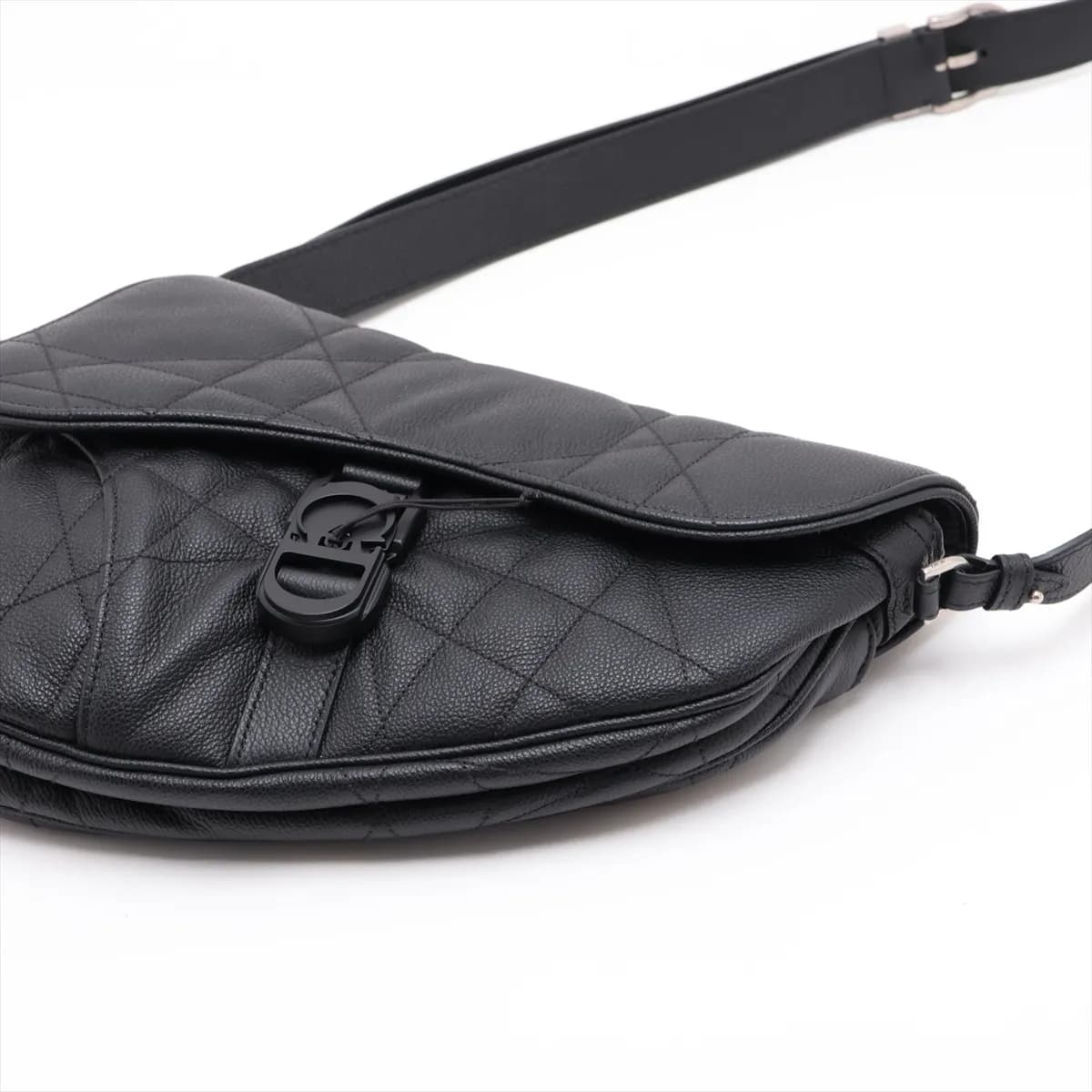 Black quilted leather saddle-shaped bag with star motif stitching and a wide shoulder strap