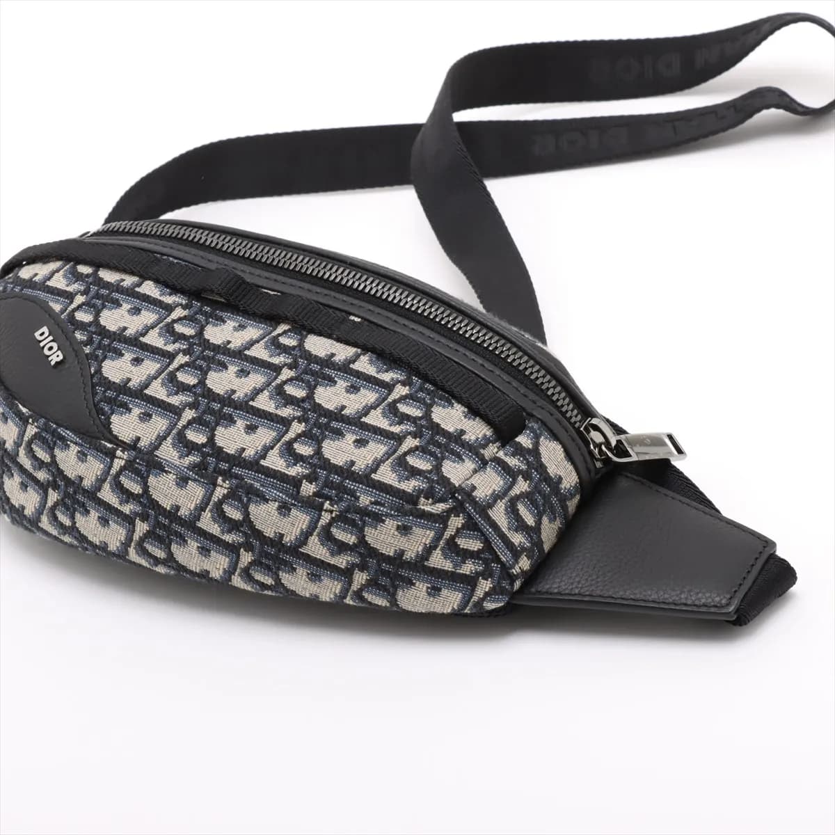 Navy jacquard-patterned canvas body bag with leather trim, buckle strap and front zip pocket
